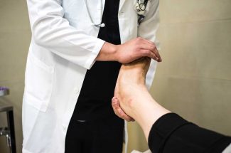 doctor readjusting patients bruised ankle